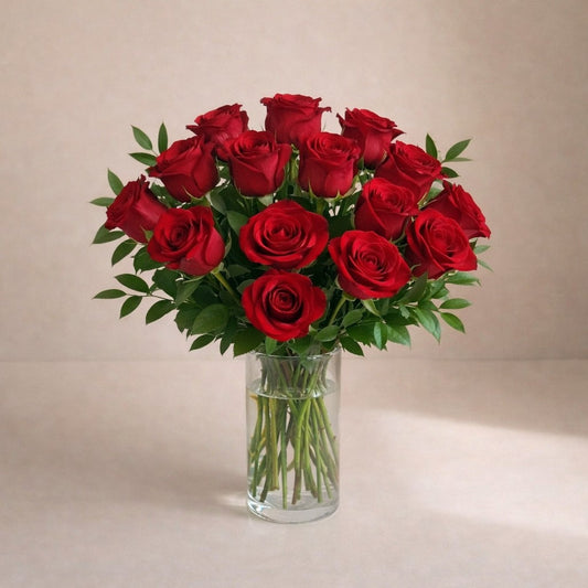 Elegant red rose bouquet in a clear glass vase, featuring rich red roses and refined Italian ruscus greenery – Encinitas flower delivery