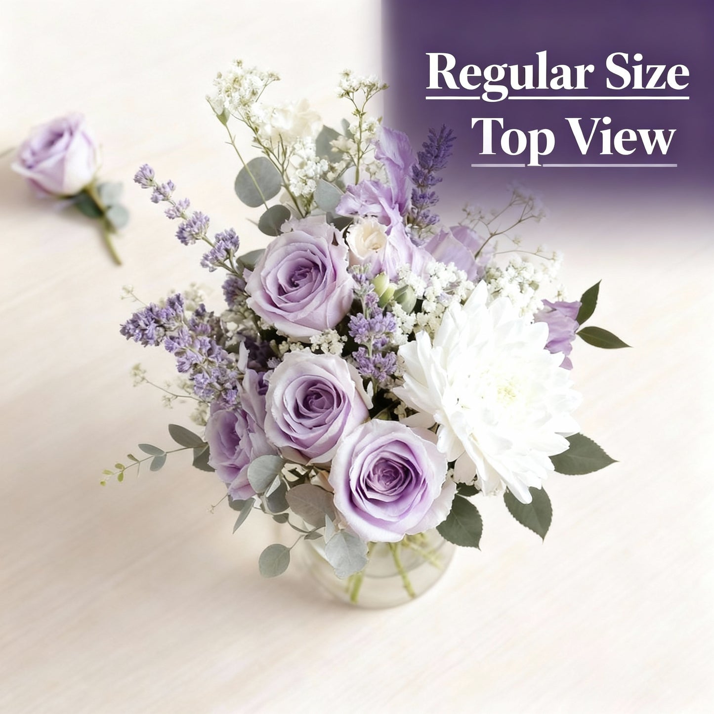 Top view of regular size pastel purple and white fresh flower arrangement with roses, mums, daisies, and greenery in a clear glass vase — Same-day flowers Carlsbad.