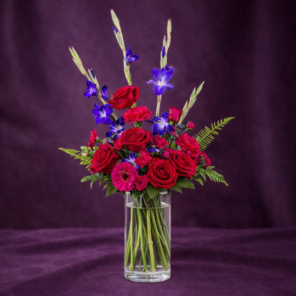 Premium size Romantic Purple & Pink Bouquet with abundant red roses, pink gerberas, purple gladiolus, and layered greenery in a vase, Same-day flowers Encinitas.