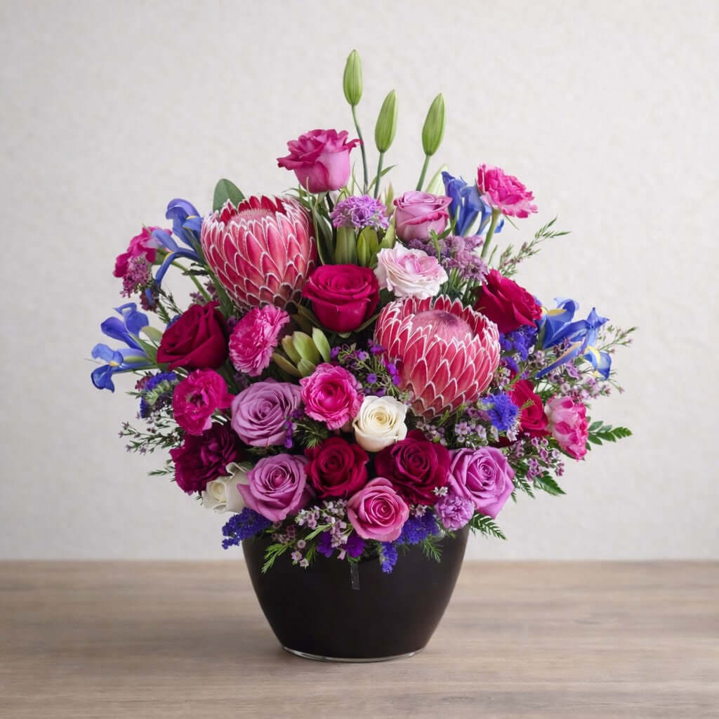 Luxury Pink Flower Arrangement featuring king protea, roses, and seasonal blooms in a stunning floral display.