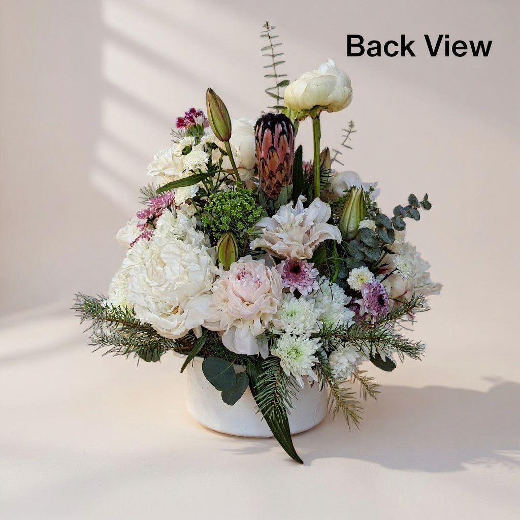 Back view of white and blush peony rose vase arrangement with mums, lilies, and mini carnations, styled in a white ceramic vase - San Marcos flower delivery.