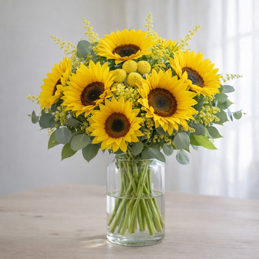 Extra full size sunflower bouquet with lush yellow filler flowers and eucalyptus in clear vase – Oceanside delivery
