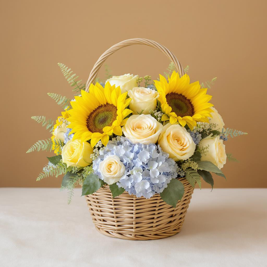 Deluxe size sunflower and rose basket with fuller blooms, enhanced blue hydrangeas, and added greenery arranged in a woven wicker basket — Escondido flower delivery.