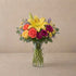 Regular size Amber Celebration yellow lily and orange rose bouquet in clear glass vase with eucalyptus and yellow button blooms – San Marcos flower delivery