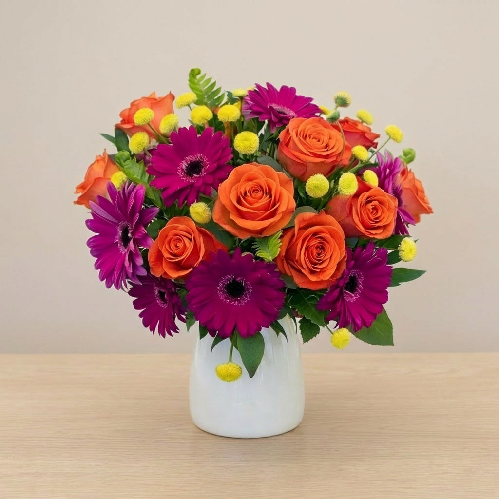 Extra full size Sunset Spark deluxe size vase arrangement with orange roses, pink gerbera daisies, and fresh greenery, Carlsbad flower delivery.