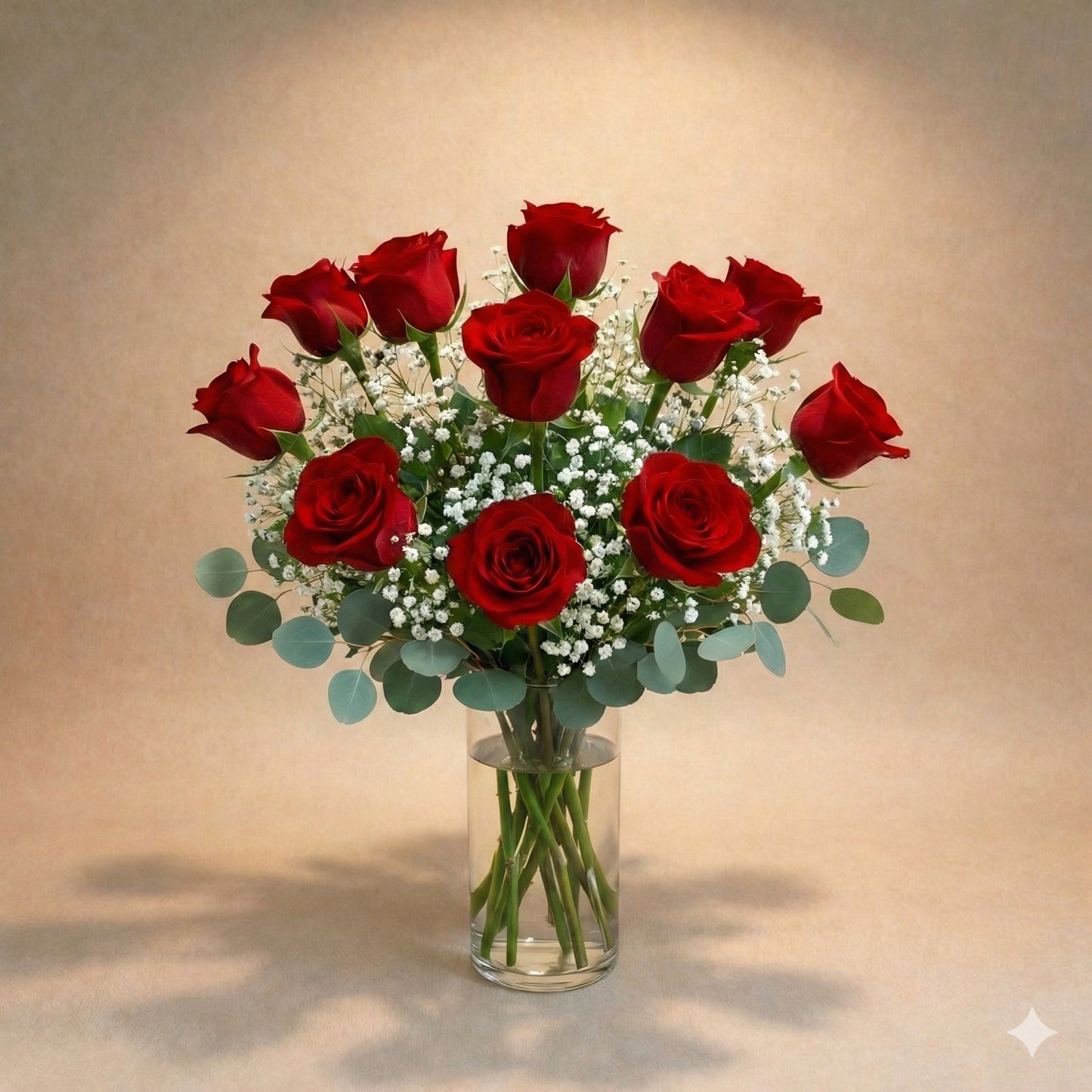 Regular size classic red rose arrangement with long-stem red roses, white baby’s breath, and greenery in a clear round glass vase — Vista flower delivery.