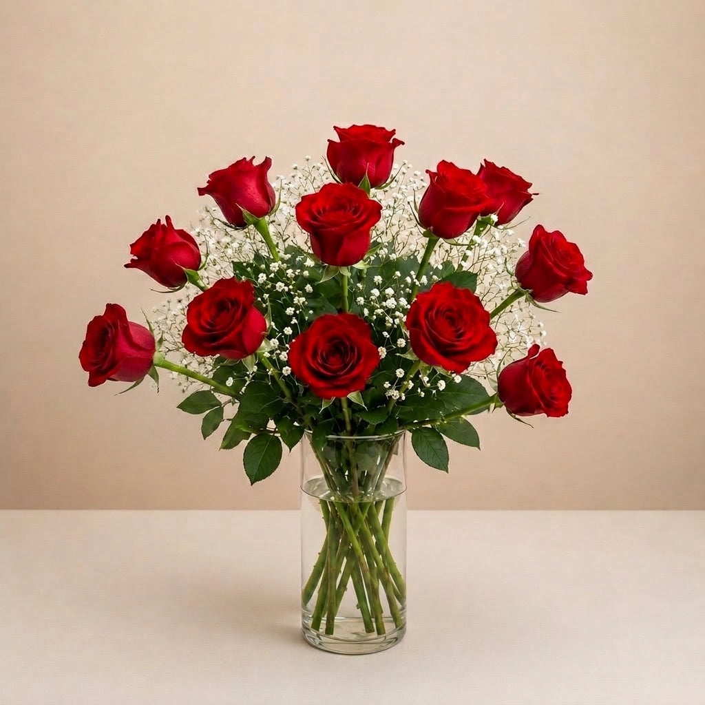 Regular size classic red rose arrangement with long-stem red roses, white baby’s breath, and greenery in a clear round glass vase — Vista flower delivery.