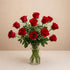 Regular size classic red rose arrangement with long-stem red roses, white baby’s breath, and greenery in a clear round glass vase — Vista flower delivery.