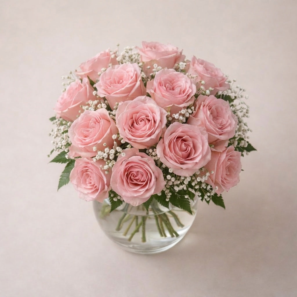 18 blush roses in clear vase with elegant pink blooms