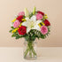 Elegant Lily & Rose Harmony Vase featuring white lilies and red, pink roses with yellow fillers in a clear glass vase.