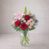 Regular size pink lily and red rose vase arrangement with spray roses, soft lavender fillers, and light greenery in a clear glass vase. Fresh flowers Encinitas CA