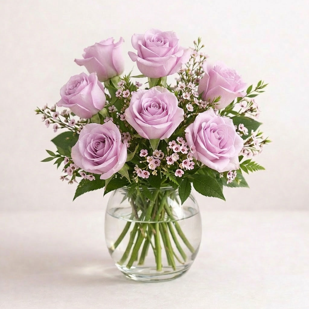 Soft lavender and blush pink rose arrangement with airy spacing and light fillers in a clear round glass vase, designed with natural balance and gentle elegance, fresh flowers Escondido CA.
