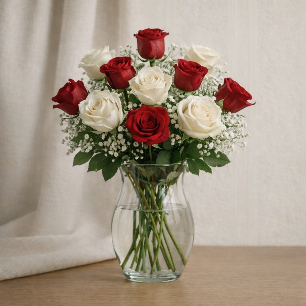 Red and white rose arrangement in a clear glass vase with soft greenery, balanced and elegant floral design, handcrafted flower delivery in Encinitas, CA