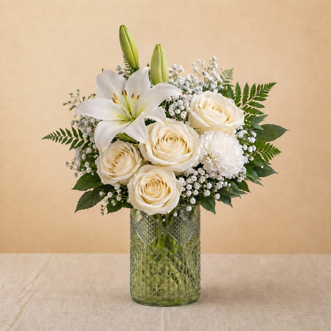 Regular size Serenity Grace white sympathy arrangement featuring white lilies, ivory roses, chrysanthemums, and soft greenery in a clear glass vase — Escondido florist.
