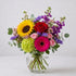 Regular size sunflower and rose vase bouquet featuring additional pink gerbera daisies, lush greenery, and balanced color in a clear glass vase — same-day flower delivery Oceanside.