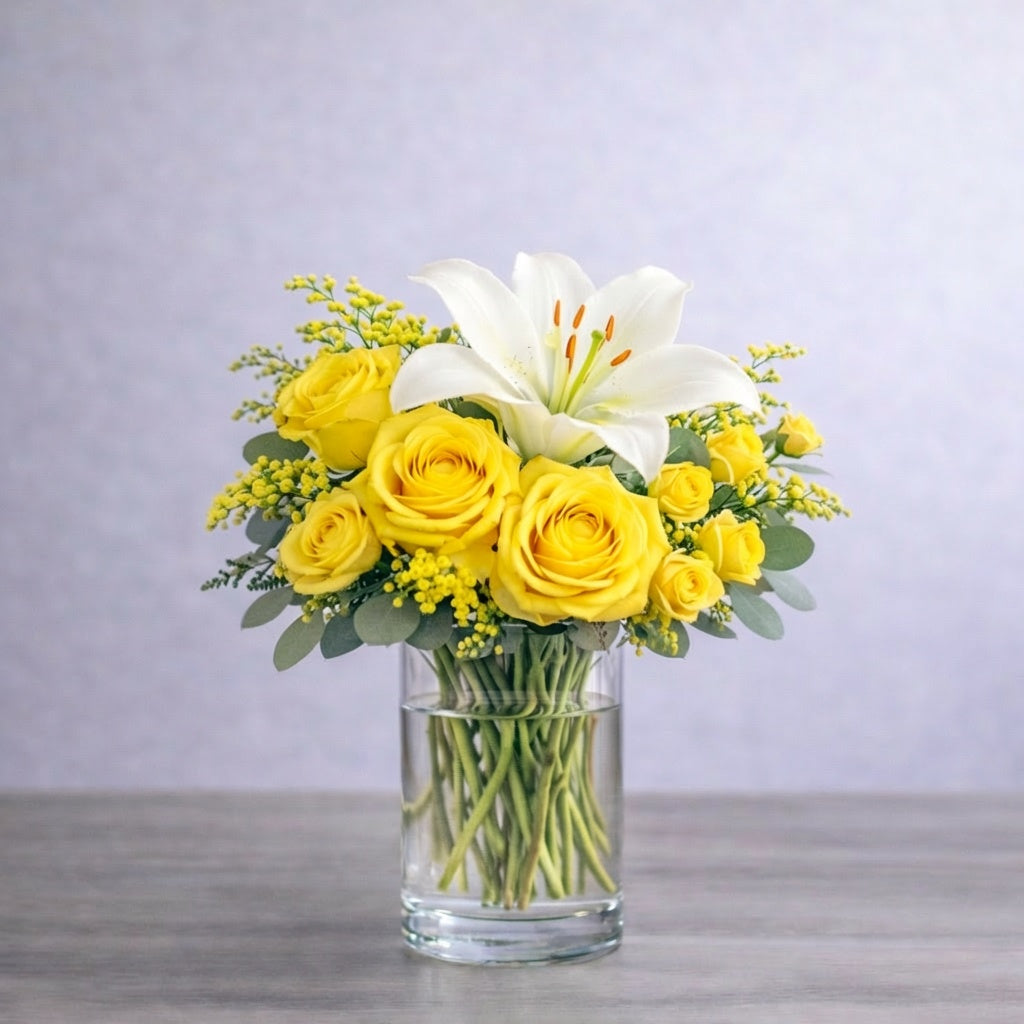 Sunshine Radiance yellow lily and rose vase arrangement with bright yellow roses and white lilies in a clear glass vase, available for flower delivery in Escondido.