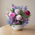 Pink and lavender flower bowl arrangement with soft garden blooms