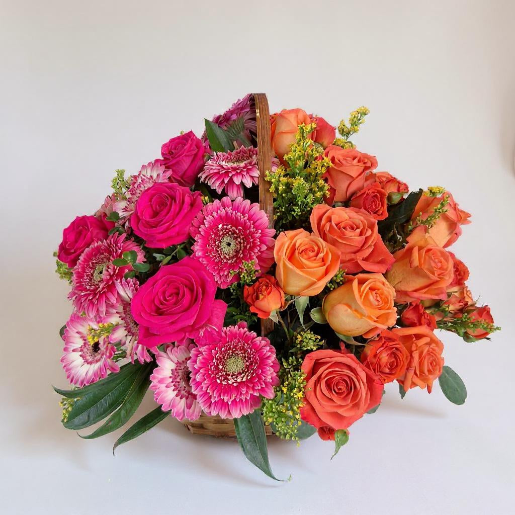 Bright pink and orange rose flower basket with gerbera daisies and seasonal greenery, handcrafted floral arrangement in a woven basket - Fresh flowers San Marcos CA.