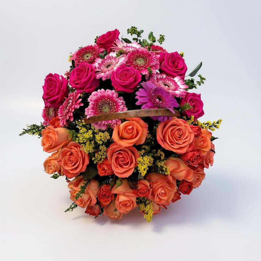 Pink and orange rose arrangement featuring vibrant roses and gerbera blooms in a beautiful basket. Send a colorful floral gift with local delivery from Thanks Flowers.