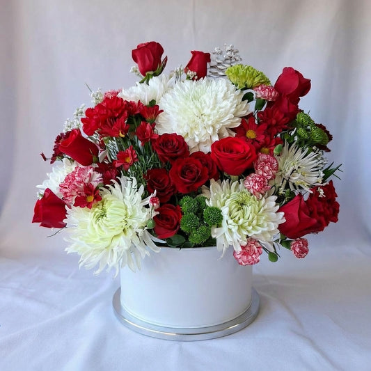 Red and white floral basket arrangement featuring premium red roses, white chrysanthemums, and seasonal greenery in a clean white container - San Marcos flower delivery.
