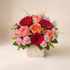 Pink and Red Flower Arrangement featuring blush roses and red gerbera daisies in a garden box.