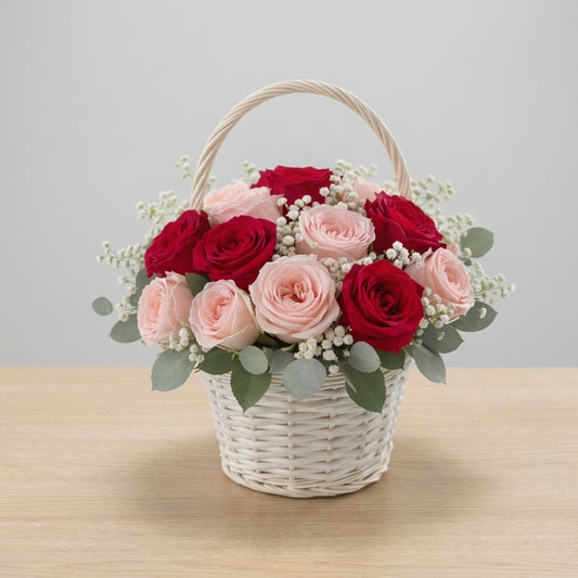Full size pink and red rose basket arrangement with baby’s breath and eucalyptus in a white woven basket – Vista florist.