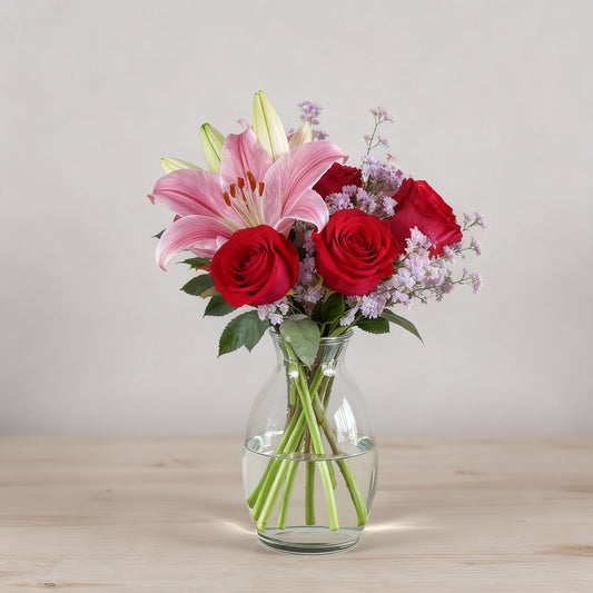 Regular size bouquet with pink lilies, red roses, and soft filler flowers arranged in a clear glass vase — Escondido flower delivery.