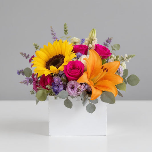 Regular size bright mixed floral arrangement with sunflowers, lilies, roses, and greenery in a white box container — Fresh flowers Carlsbad CA.