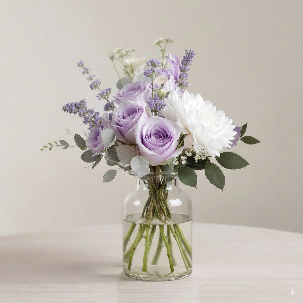 Regular size pastel purple and white fresh flower arrangement with roses, mums, daisies, and greenery in a clear glass vase — Same-day flowers Carlsbad.