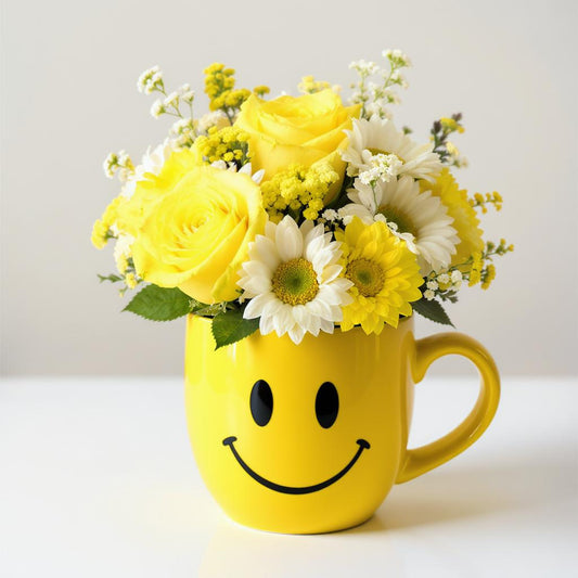Regular size cheerful yellow bouquet with roses, daisies, and mixed flowers arranged in a yellow smiley mug — fresh flowers Oceanside CA.