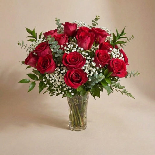 Elegant red rose bouquet in a clear glass vase, featuring rich red roses and delicate white filler flowers – North San Diego County florist