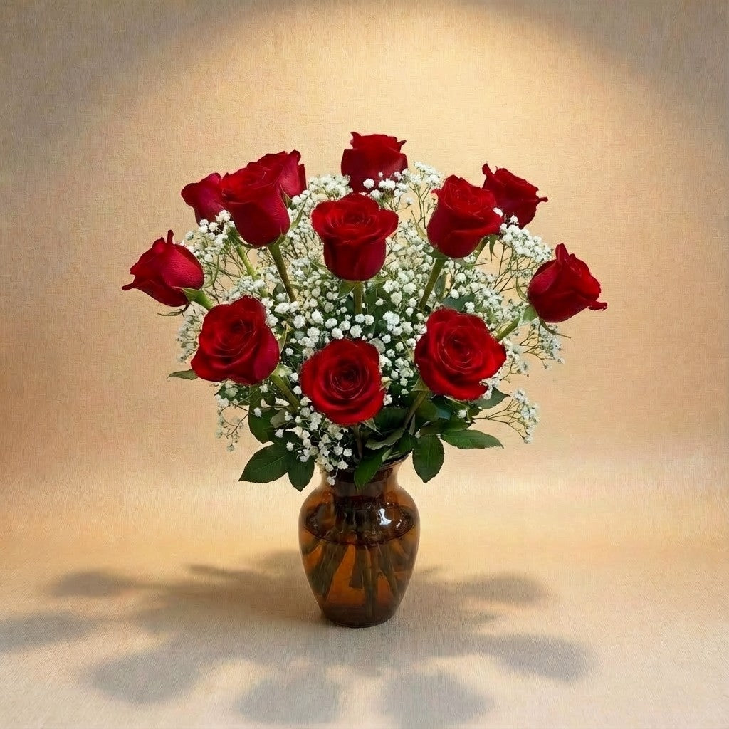 Regular size classic red rose arrangement with long-stem red roses, white baby’s breath, and greenery in a clear round glass vase — Vista flower delivery.