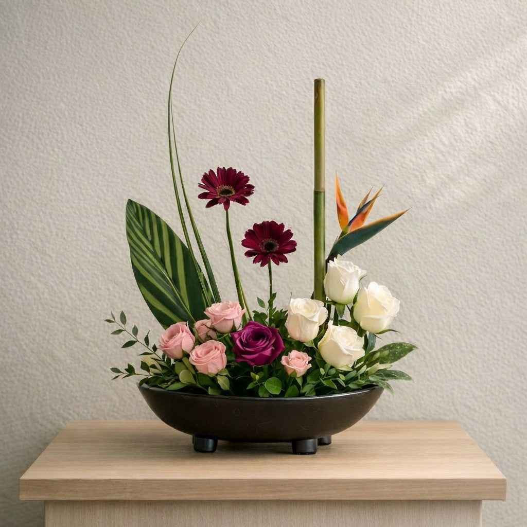Modern zen bowl flower arrangement with roses, gerbera daisies, bird of paradise, and bamboo for lobby and reception spaces in North San Diego County
